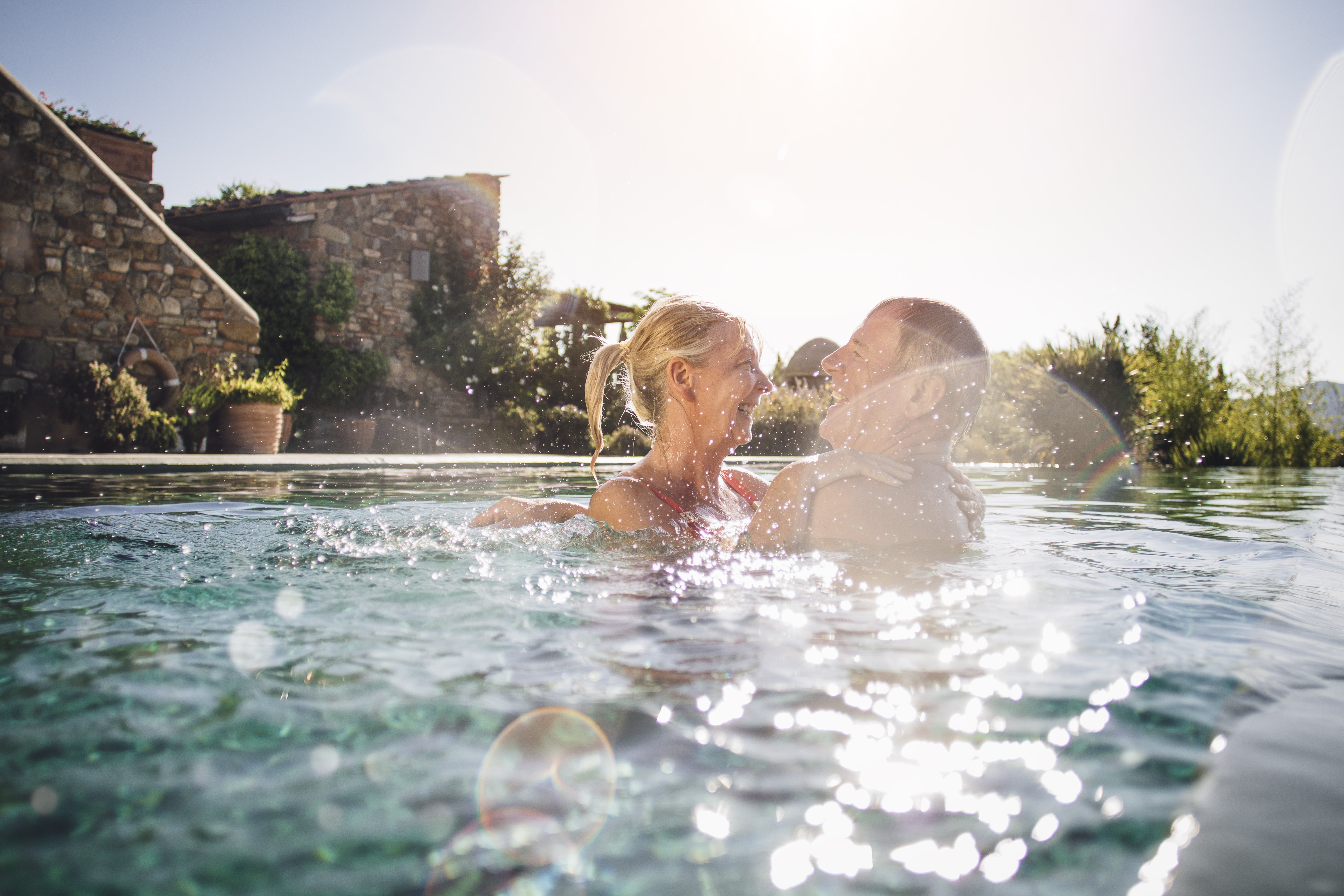 man and woman happy and smiling in backyard swimming pool