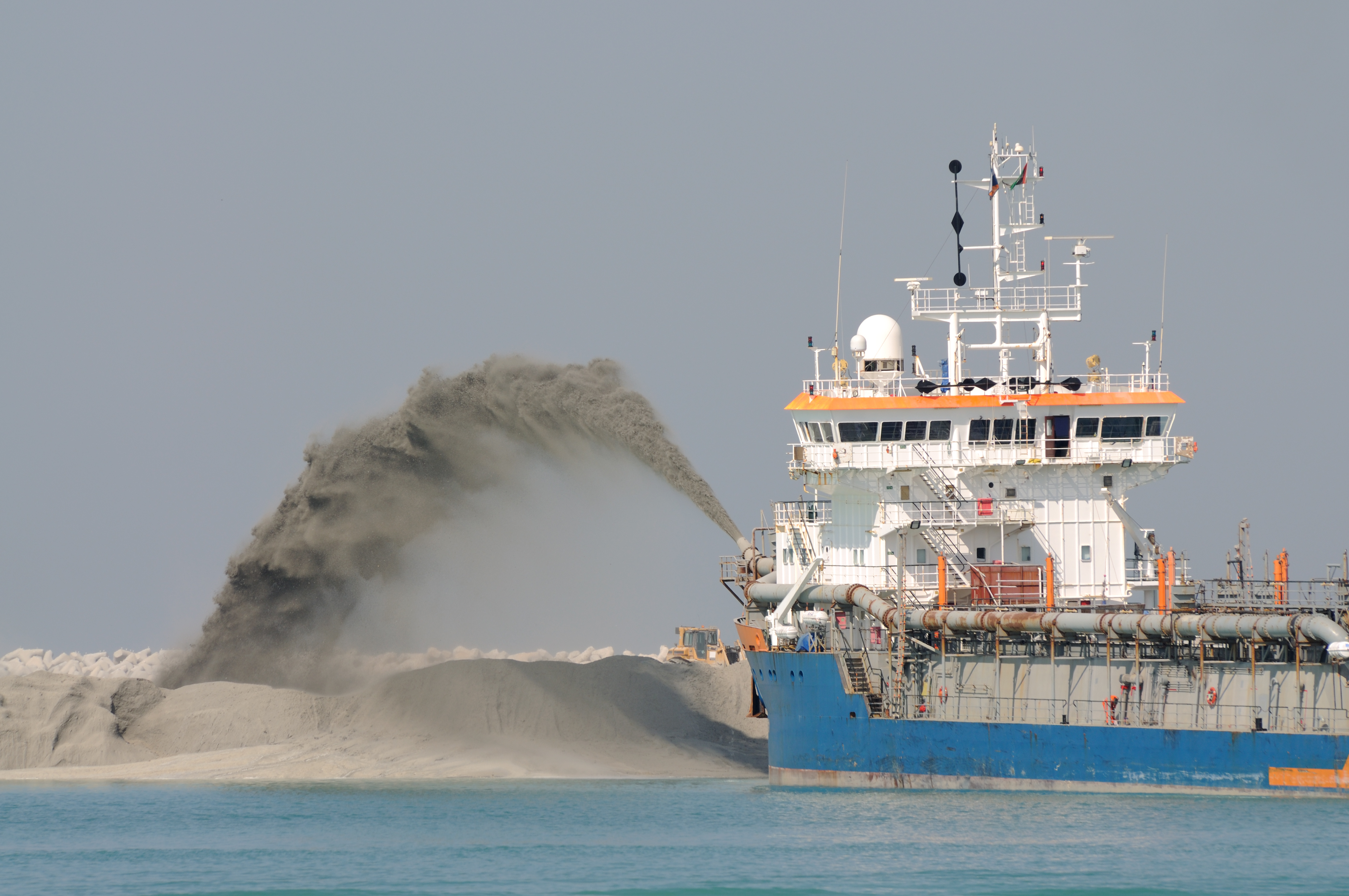 Special dredge ship pipe pushing sand to create new land in Dubai, United Arab Emirates