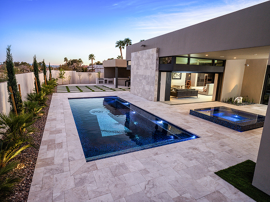 rectangular swimming pool and spa. A keyhole design in at the bottom of the pool. Geometric house. 