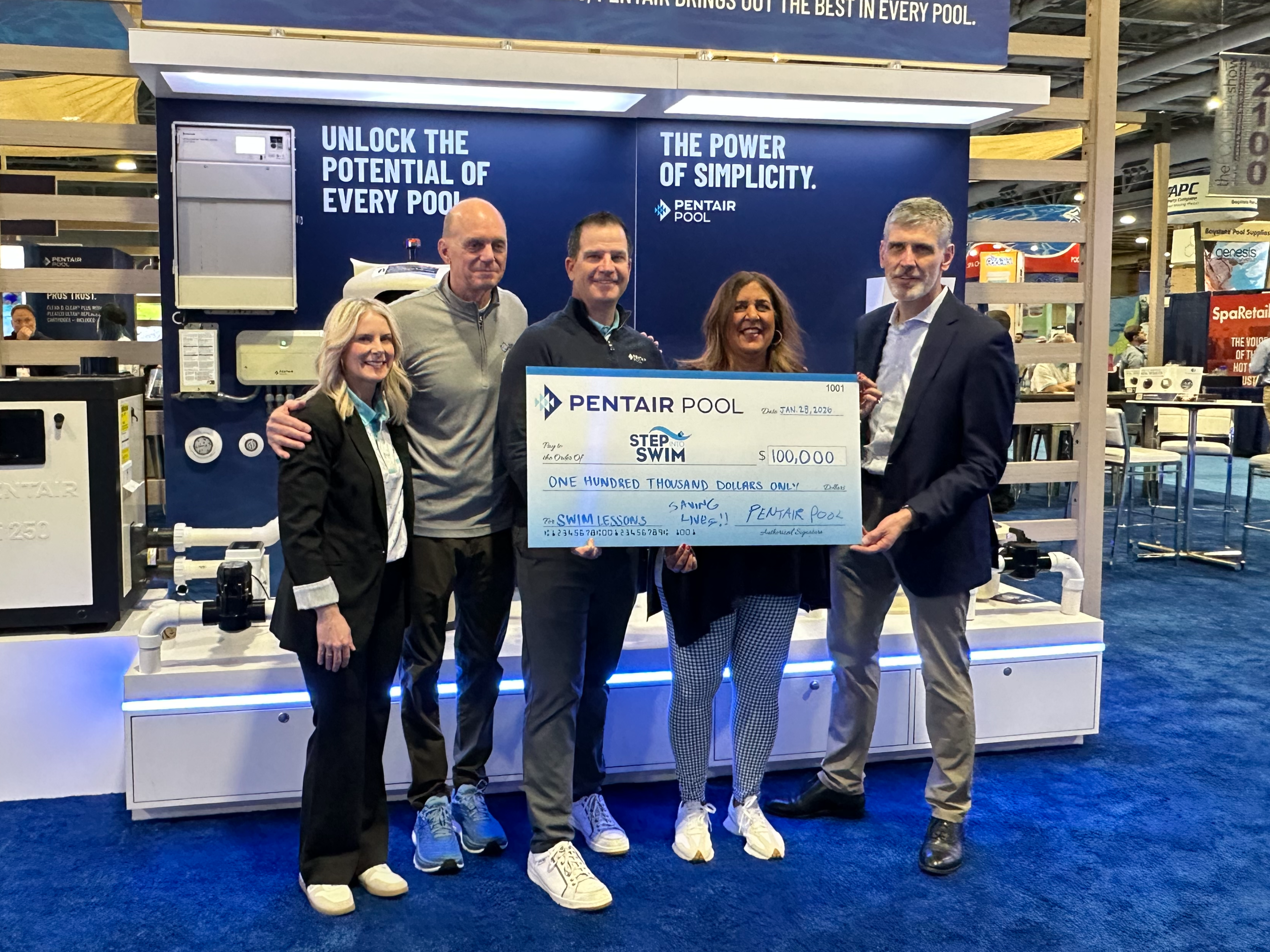 Group photo of two women and three men from Pentair posing with 100,000 check.