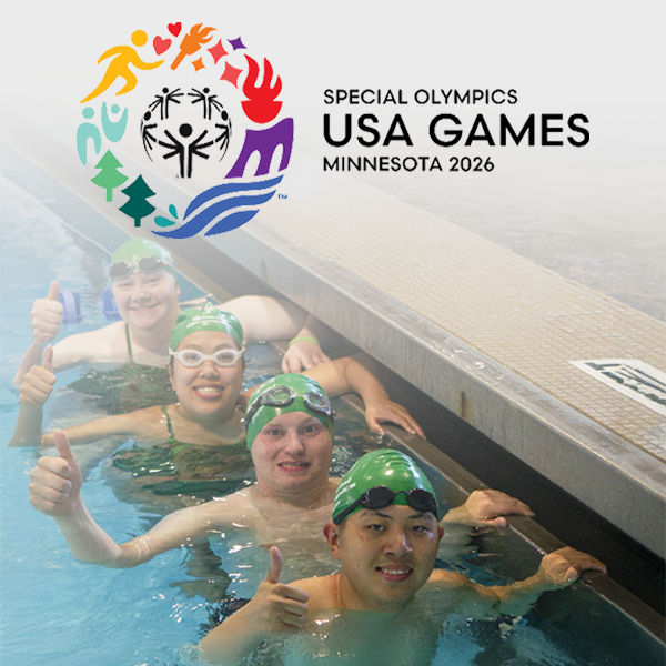 A group of special olympic swimmers smiling at the side of a pool. Special Olympics logo on the left.