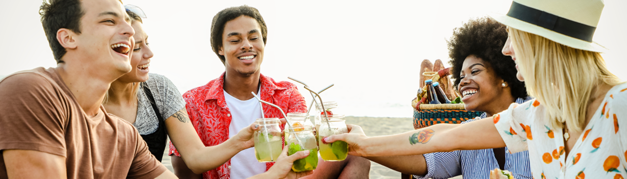group-of-friends-drinking-fruit-infused-water-on-the-beach-having-a-picnic