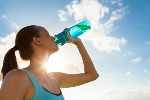 female-athlete-wearing-blue-shirt-drinking-water-from-bottle-with-blue-sky-on-sunny-day-horizontal-5616x3744-image-file-519369740
