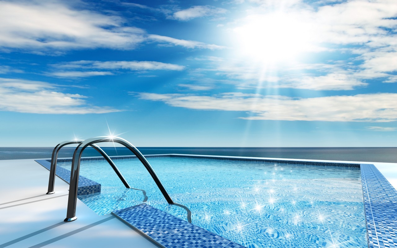 sun glistening shiny blue outdoor pool near ocean clear blue sky