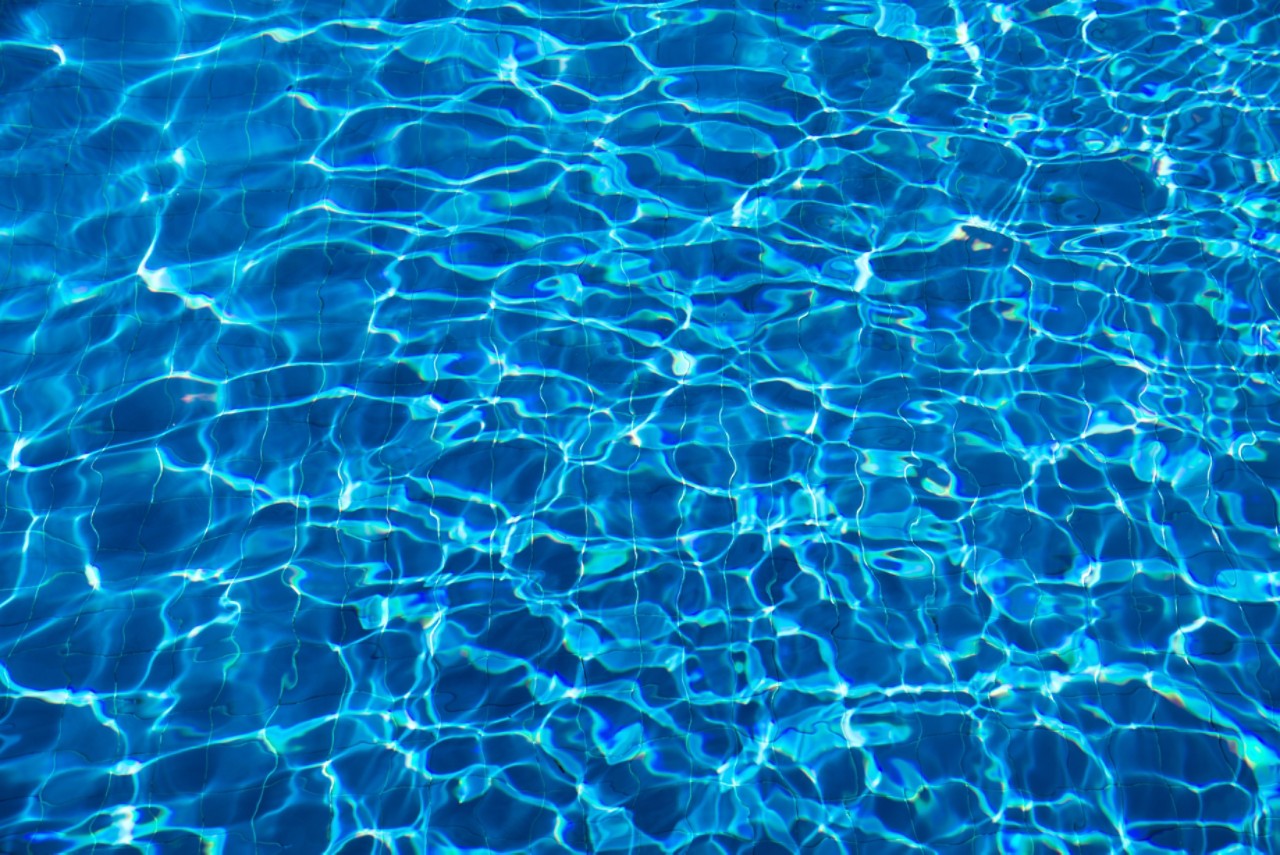 closeup of blue reflective rippling water in swimming pool