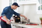 man in kitchen looking at sink