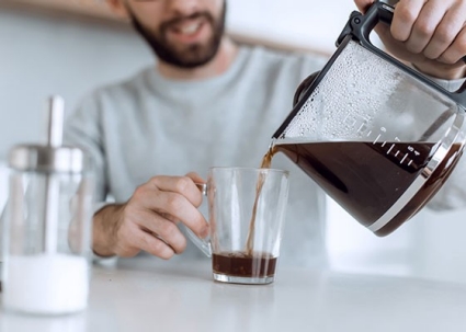 Smaller image of man pouring himself a cup of coffee 
