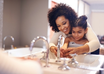 Mom and child washing hands at the sink
