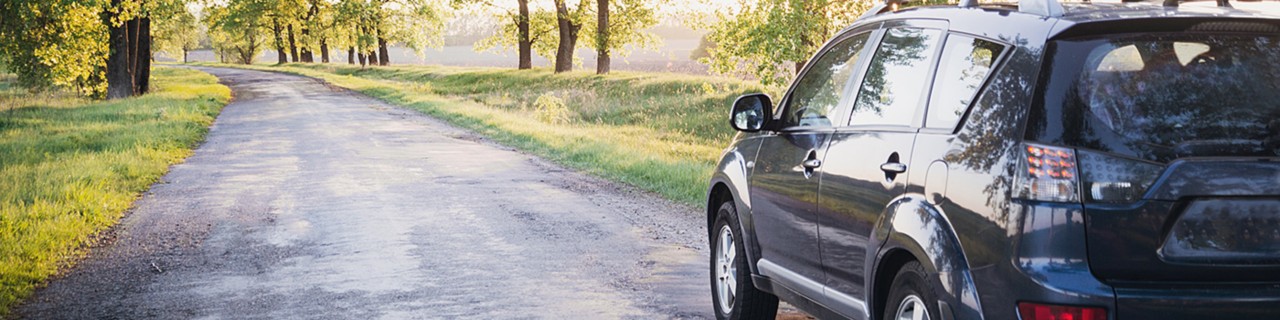 Car on a quiet dirt road in the sunlight