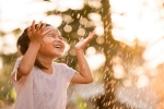 young-smiling-girl-in-pink-shirt-playing-in-sprinkler-on-sunny-day-horizontal-6000x4500-image-file-644737381