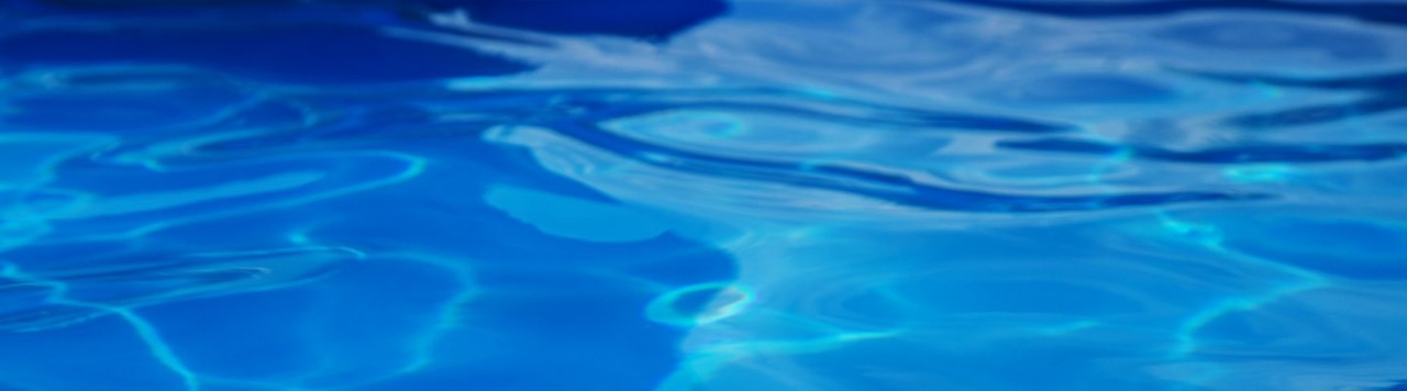 Aqua blue pool water in motion with dark ripples