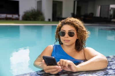 Woman in blue swimsuit on phone in pool