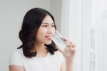 Beautiful asian girl drinking a glass of water.