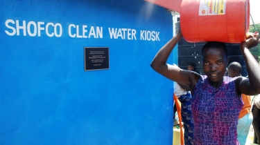 Woman holding water bucket over her head