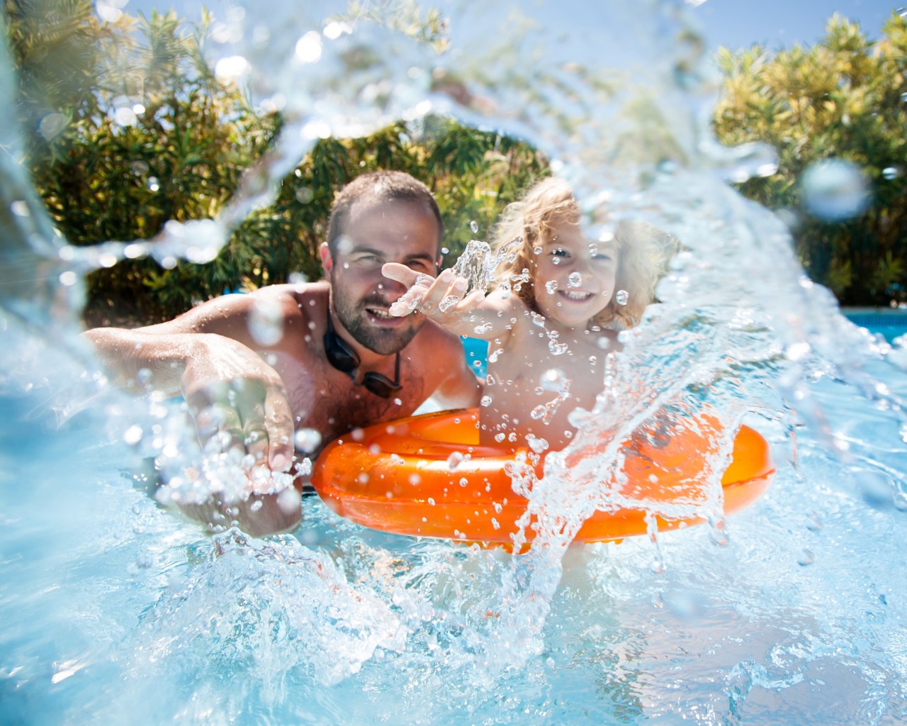 happy-man-and-young-boy-splashing-in-blue-water-on-sunny-day-horizontal-3370x2696-image-file-153362633