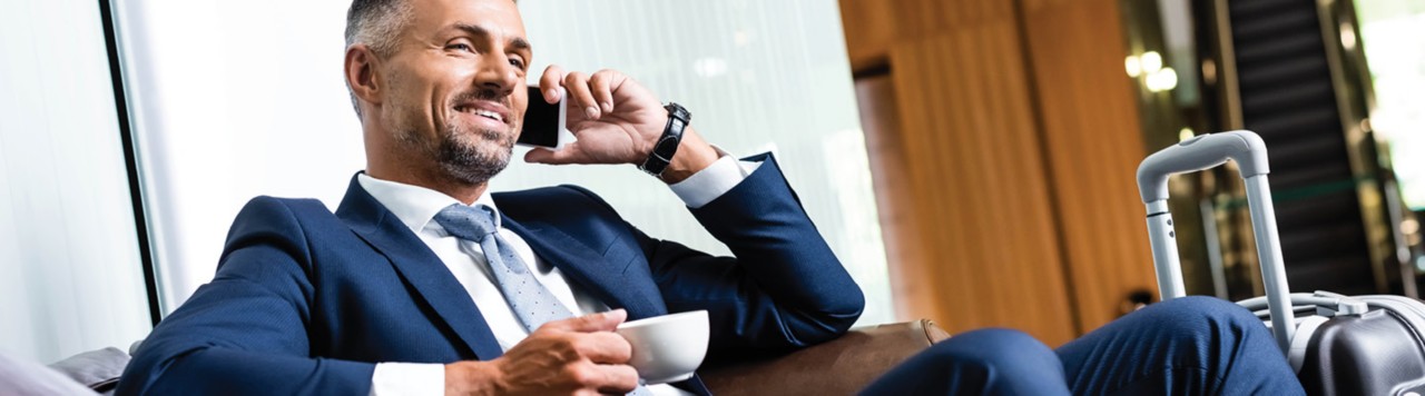 Business man drinking espresso in hotel lobby 1440x400