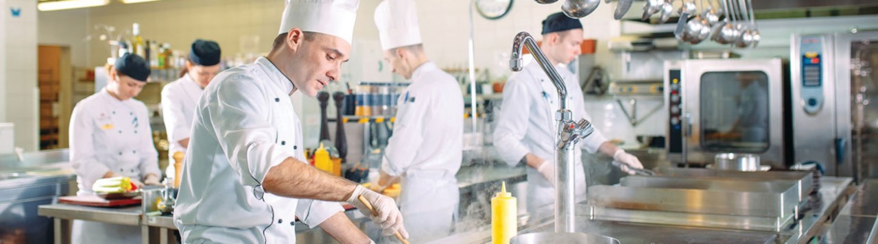 Chef cooking in a commercial kitchen 1440x400