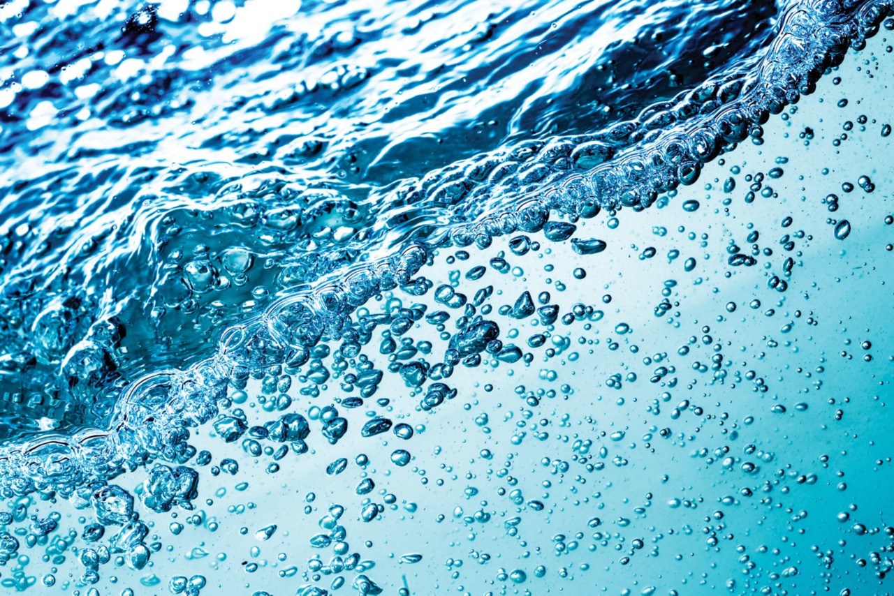 A close up shot of blue, bubbly water swirling around.