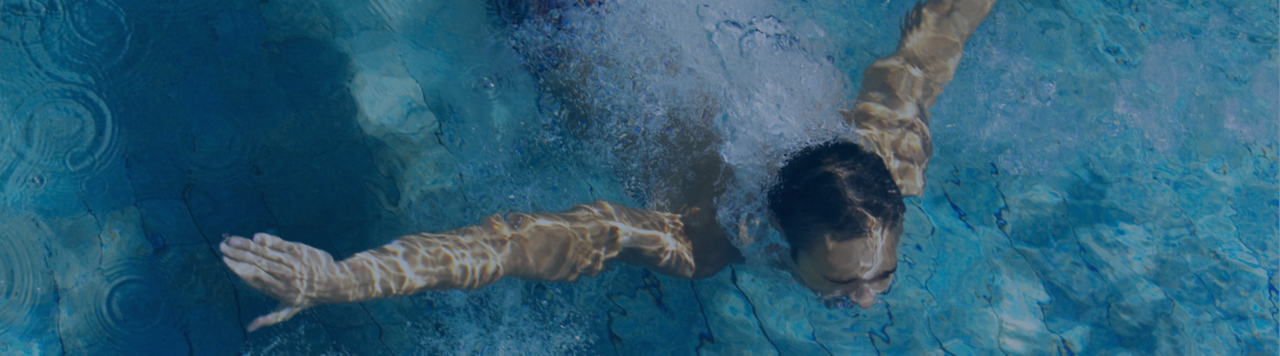 Man swimming underwater after dive