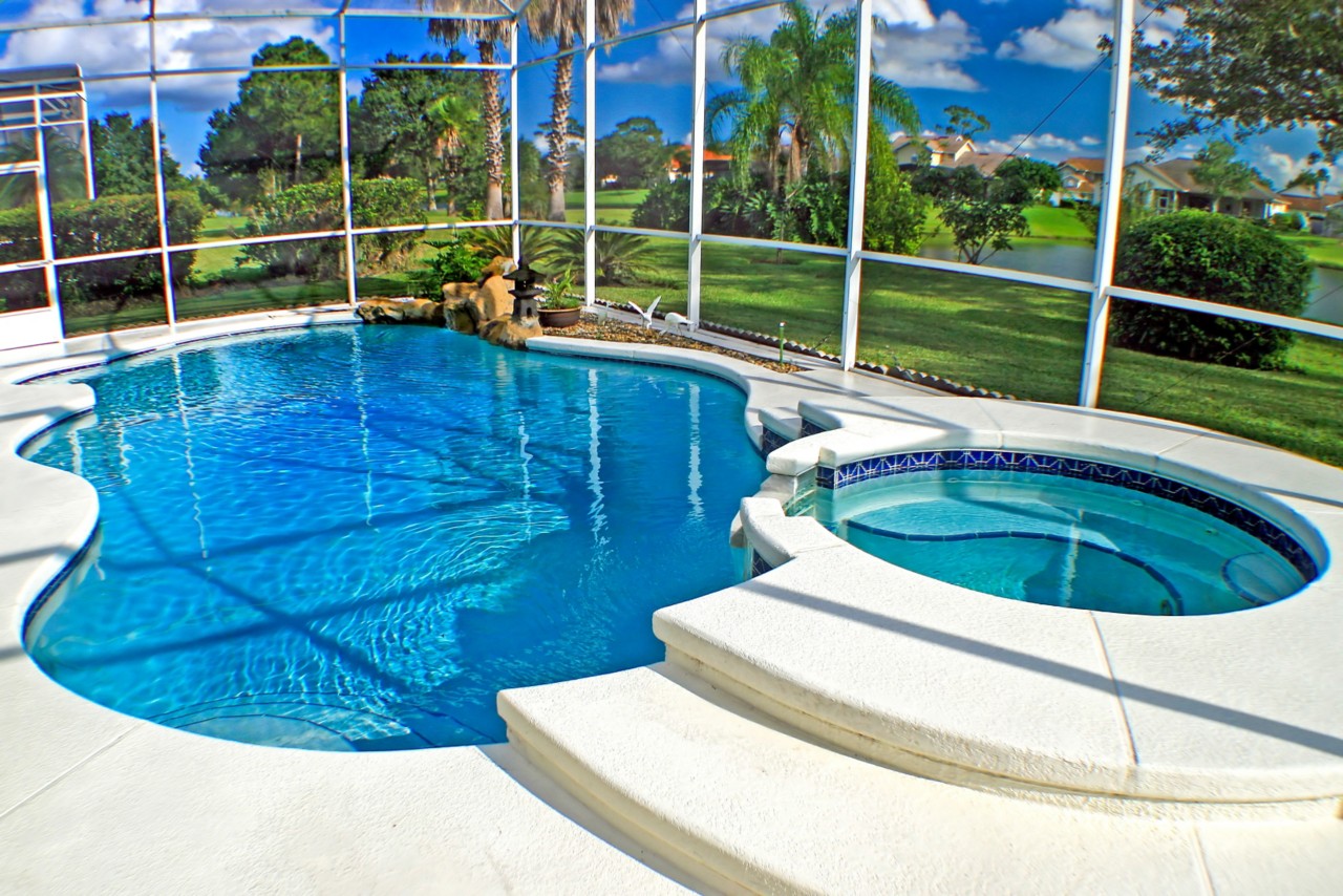 A swimming pool and spa with a lake view.