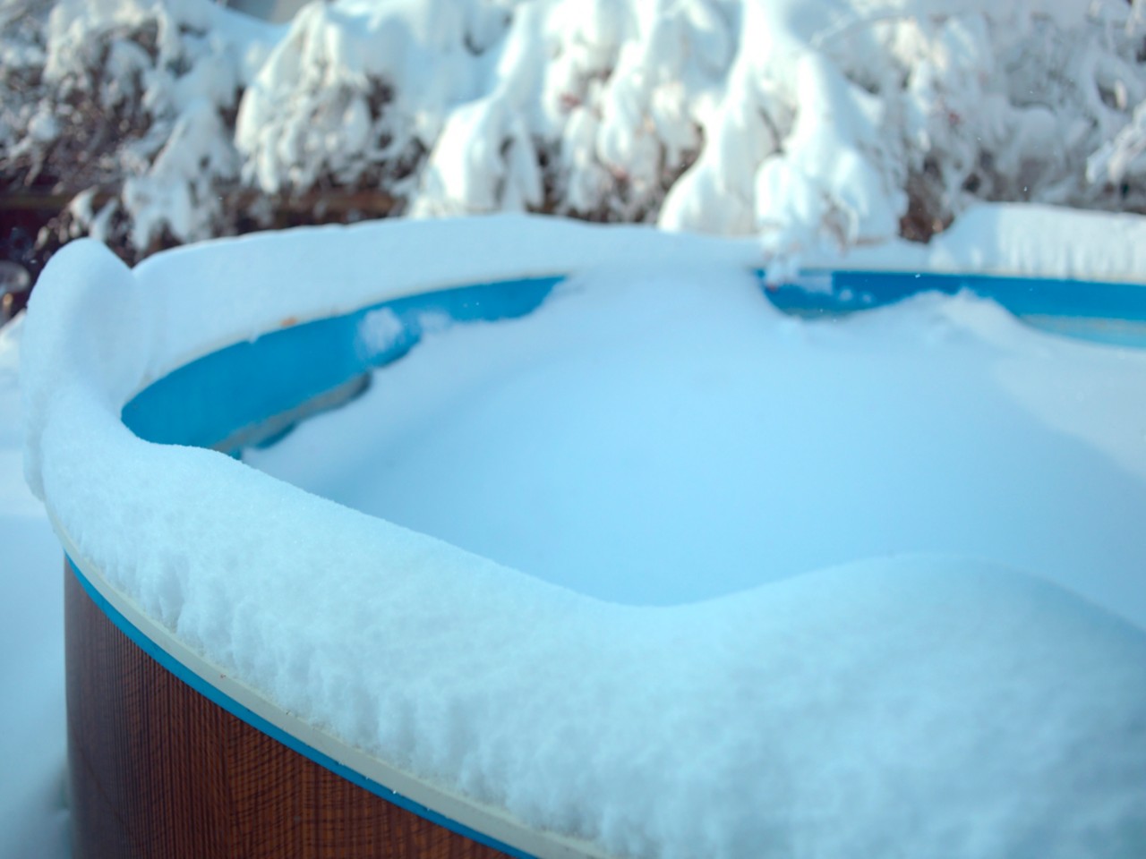A spa is covered in 3 inches of snow and ice.