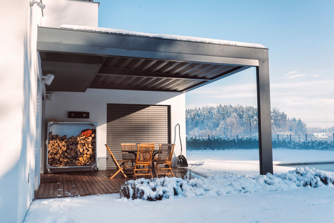 A pool deck is closed for the season with snow on the ground and roof.
