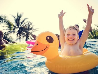 Little boy having fun in duck floating at pool