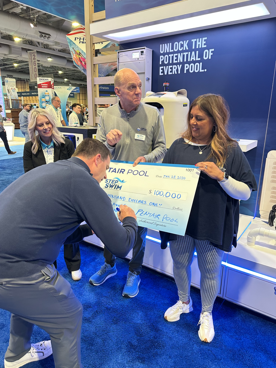 Signing the $100,000 check for Step into Swim Partnership