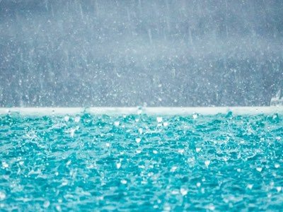 Blue pool water being rippled by heavy rain