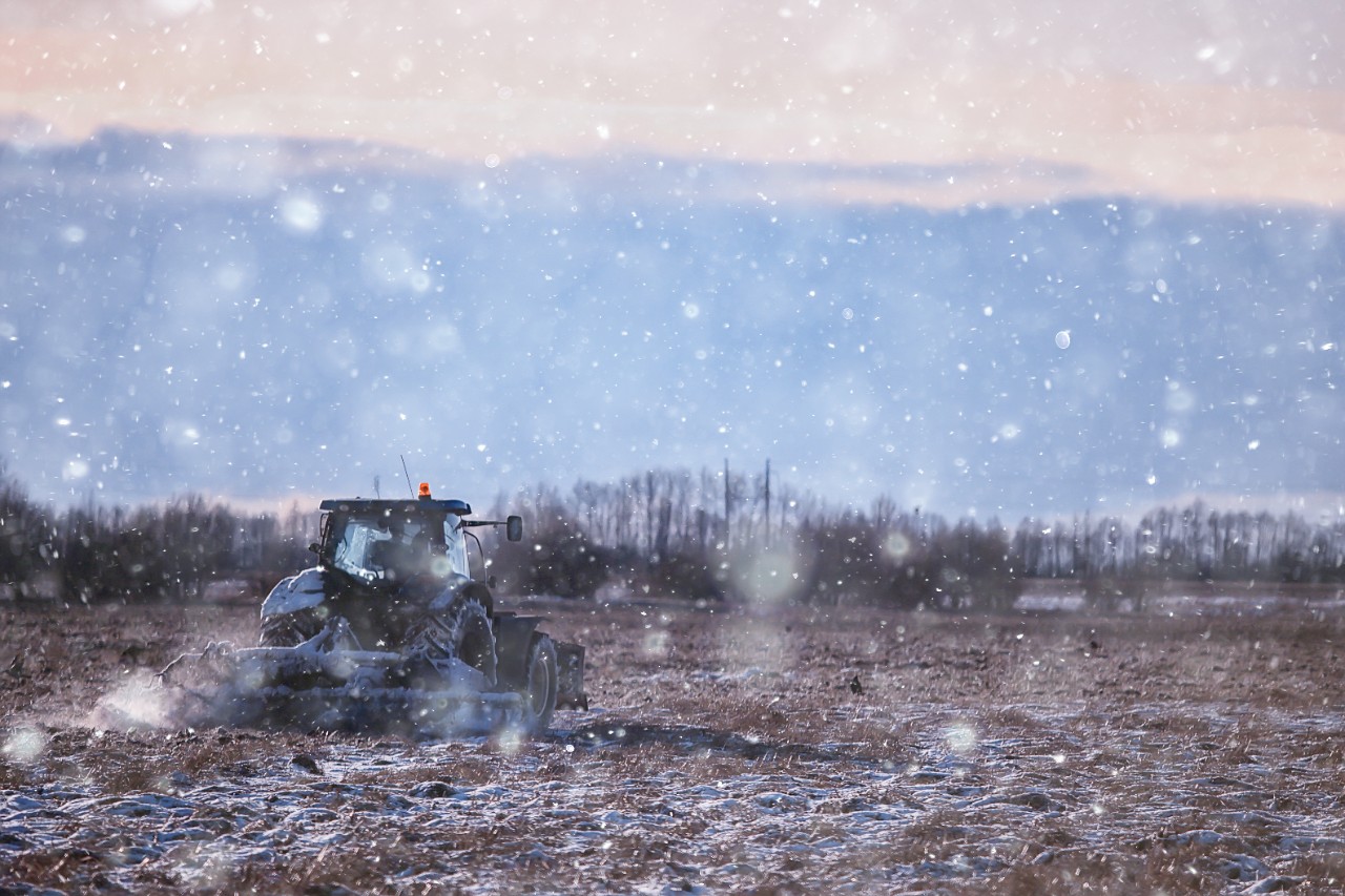 tractor in the field arable land winter agribusiness landscape seasonal work in a snowy field; Shutterstock ID 1827376280; purchase_order: Winterization Page; job: 