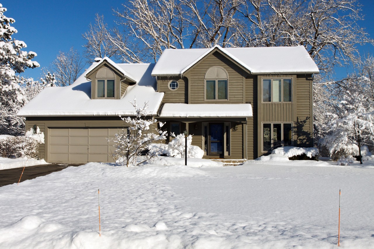 A house covered in snow with a blue sky