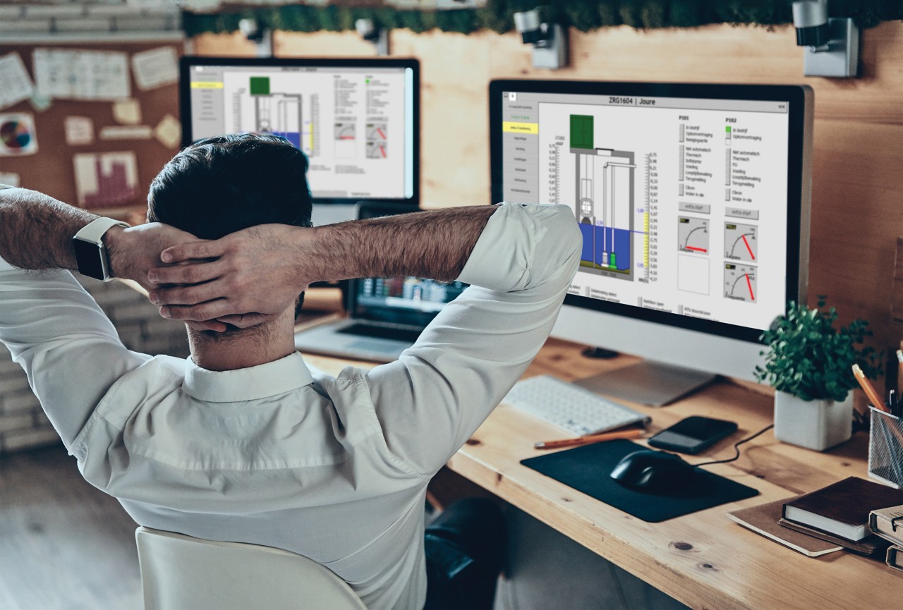 Rear view of young man in formalwear keeping hand behind head while sitting in the office; Adobe Stock: 338827218