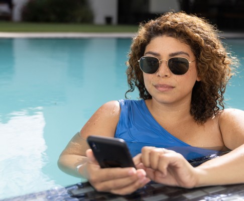 Woman in the pool on her smartphone