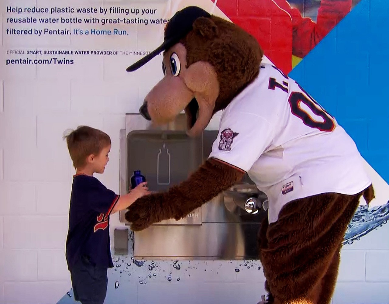 Twins mascot TC Bear with a reusable water bottle and a small child