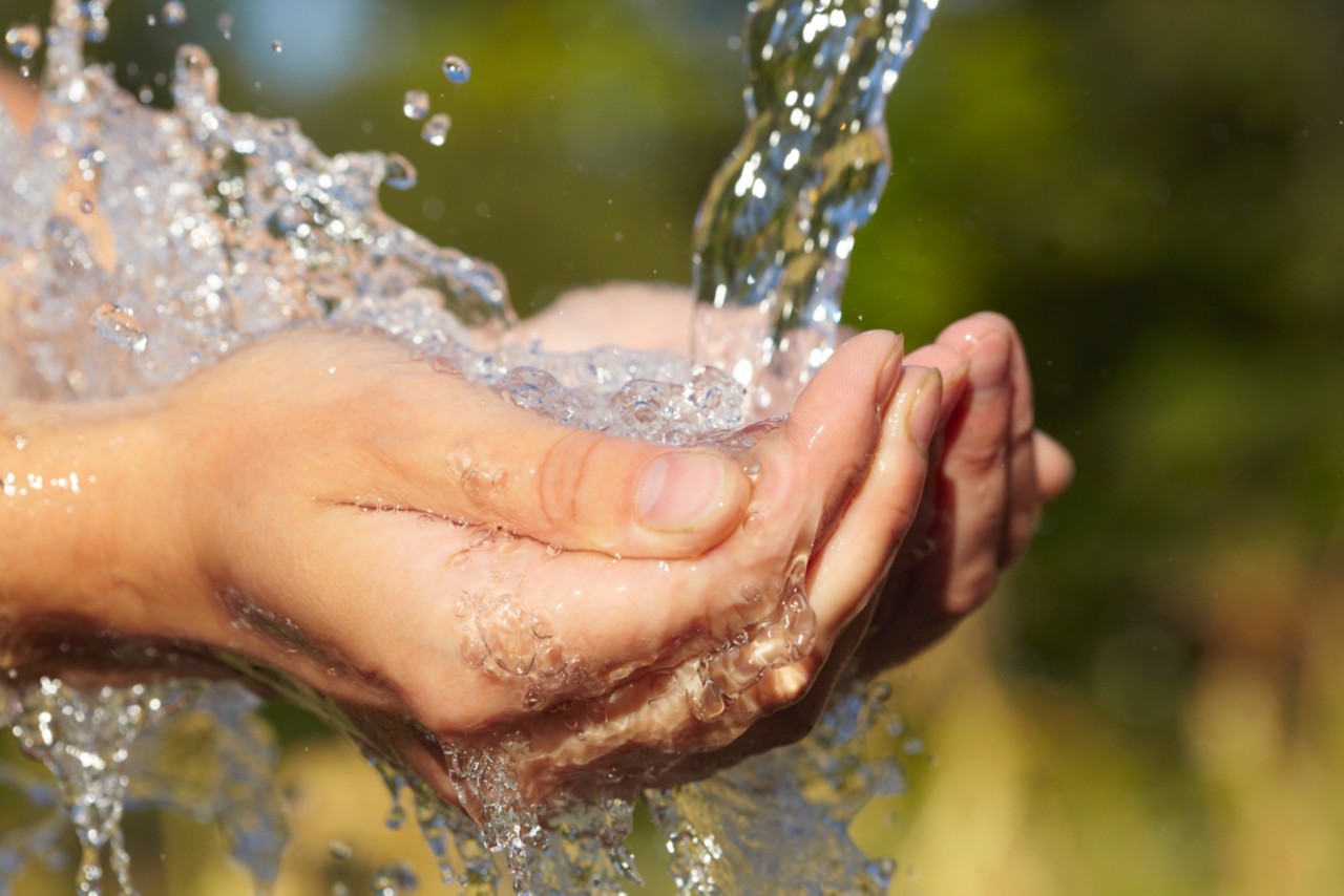 hands-holding-splashing-pure-water-with-green-background-horizontal-5616x3744-image-file-106580127