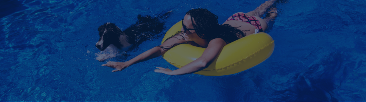 Girl in yellow foatie swimming with dog