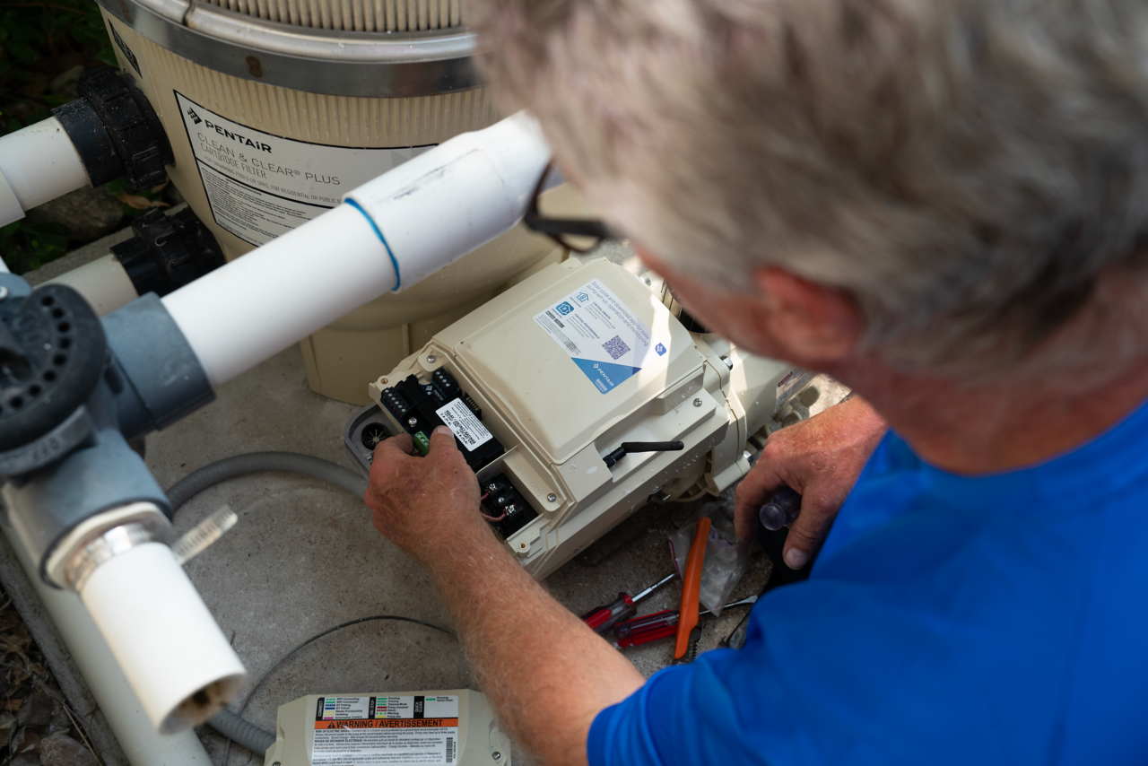 servicer installing relay board on IntelliFlo3 pump from Ham Lake Photoshoot