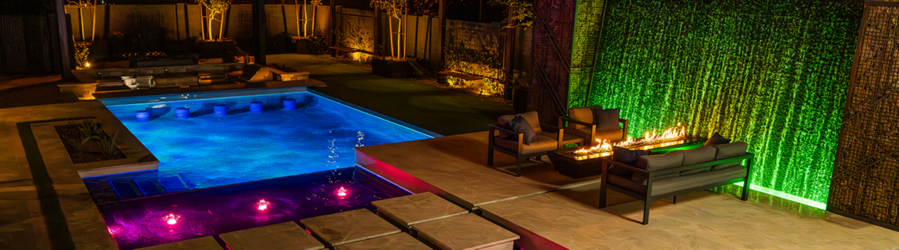 Pentair LED pool lights illuminating a sparkling backyard pool at night, creating a vibrant and inviting outdoor oasis.