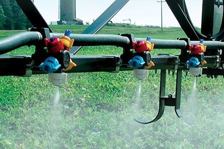 Multi-color Hypro spray nozzles spraying crops.