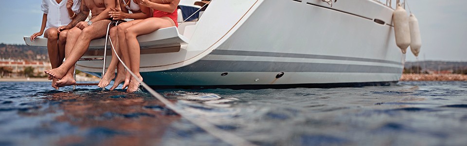 People sitting on boat feet in water; Adobe Stock: 276926297