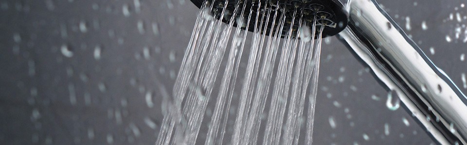 Shower spraying water with water droplets  1440x450