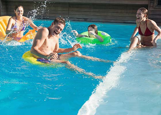 Cheerful young people playing in the swimming pool 