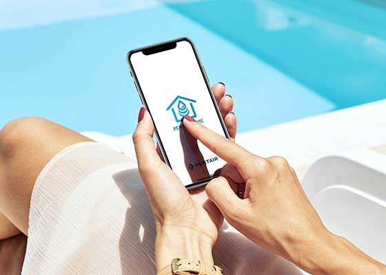 woman on phone next to clear blue pool with Pentair Home app