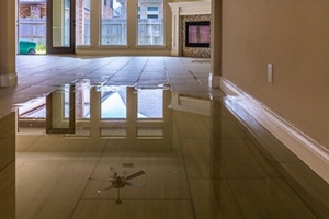 Reflective water on a flooded tile kitchen floor