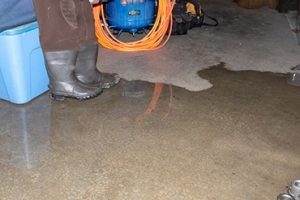 A pair of gray boots standing in a flooded basement
