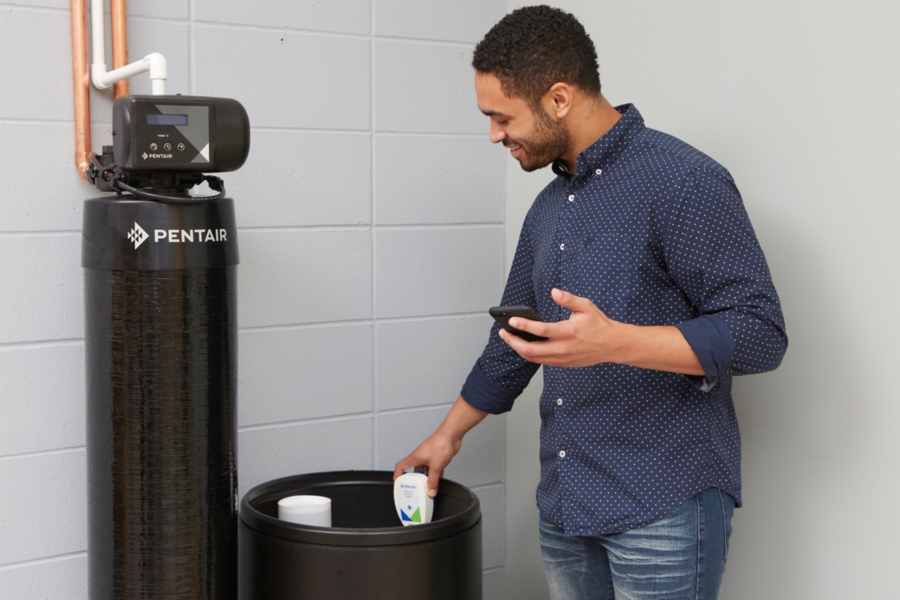 man setting up salt sensor on, clipping on brine tank