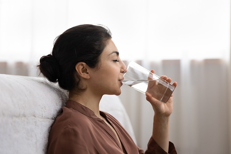 Drinking water. Side view young indian woman enjoy pure fresh cool mineral water at morning. Profile shot of thirsty millennial mixed race lady hold glass swallow crystal still aqua with closed eyes; Shutterstock ID 2040224210; purchase_order: pws blog; job: 