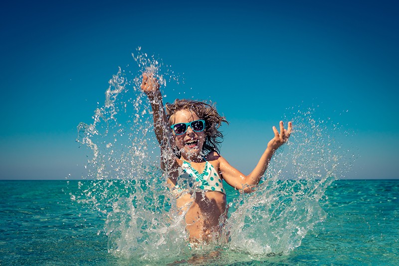 Happy child playing in the sea. Kid having fun at the beach. Summer vacation and active lifestyle concept; Shutterstock ID 663123280; purchase_order: pws blog; job: 