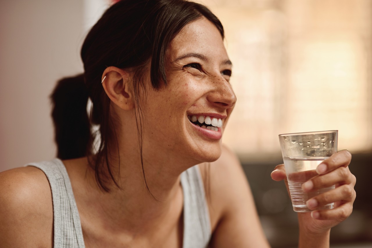 close up shot of young woman having a glass of water, water filtration, drinking water