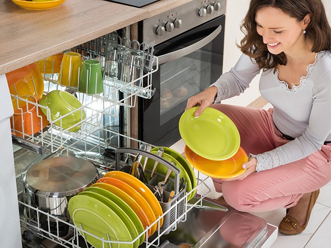 Woman emptying dishwasher